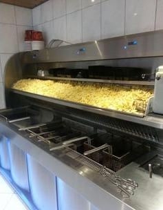Verse friet in de frituurbak van Cafetaria de Snackbar