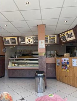 Het interieur van de cafetaria met de menuborden en de toonbank