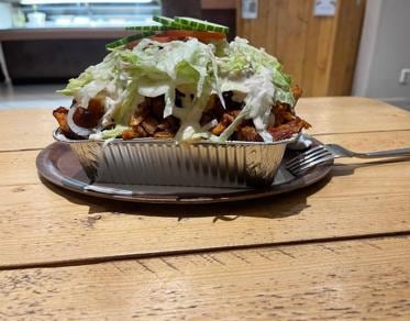 Kapsalon in een aluminium bakje met sla en knoflooksaus
